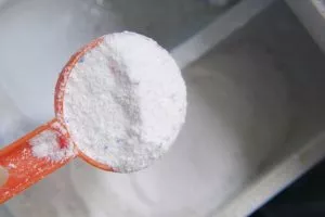 pouring washing powder from plastic spoon 260672 7420